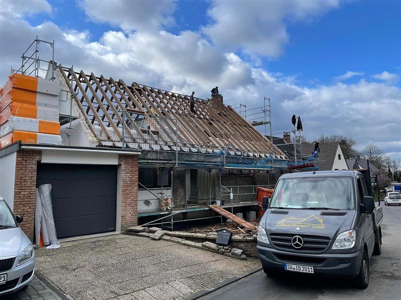 Ein Lieferwagen steht vor einem im Bau befindlichen Haus.