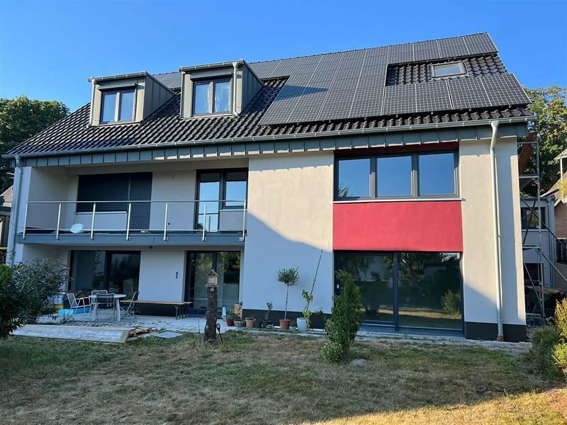 Ein großes weißes Haus mit einem roten Balkon