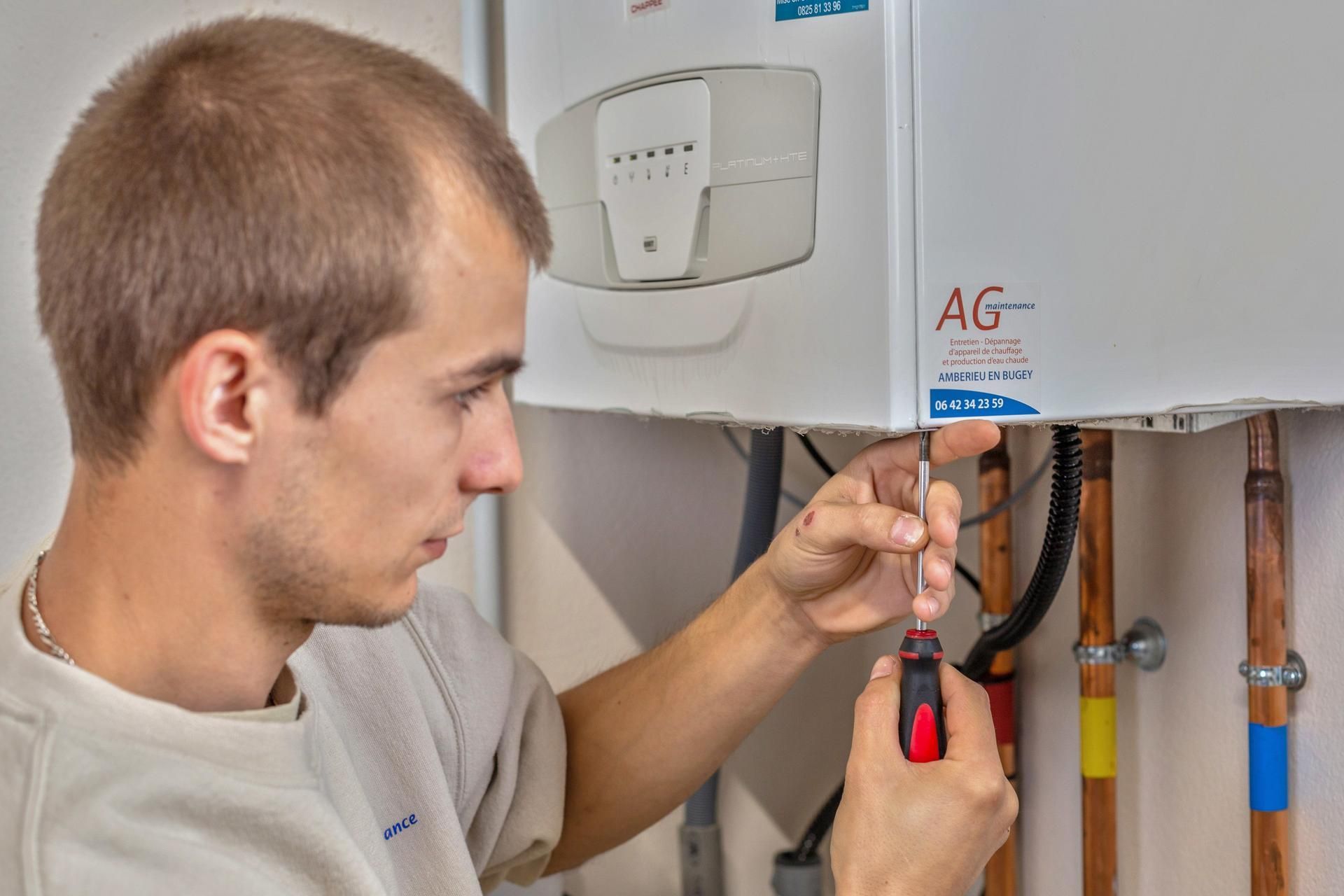 Homme réalisant l'entretien d'une chaudière.