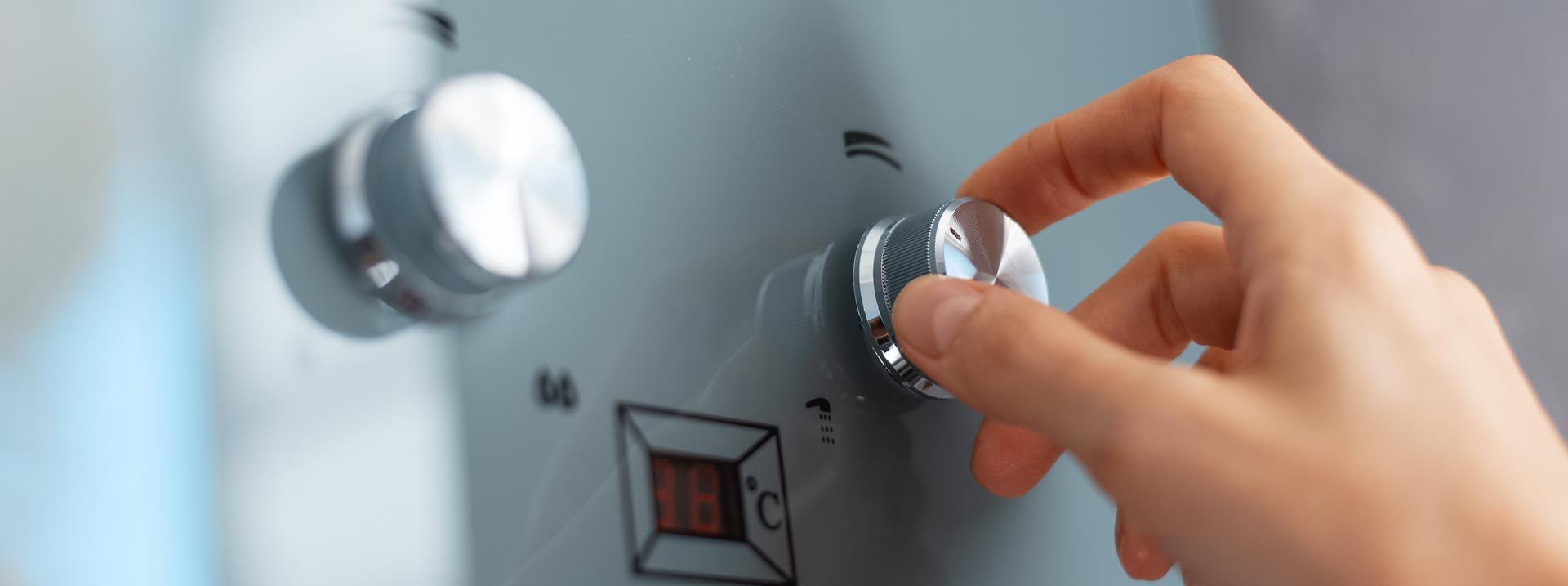 Une main tourne le bouton d'une machine grise.