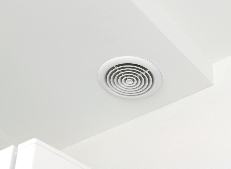 Grille d'aération de plafond blanche avec grilles circulaires concentriques.