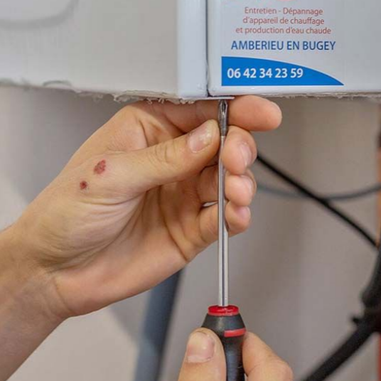 Une personne utilise un tournevis pour serrer quelque chose sur un panneau blanc.