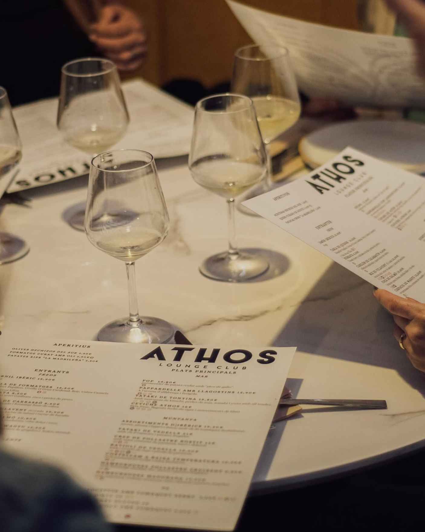 Una persona está mirando un menú en el restaurante Athos.