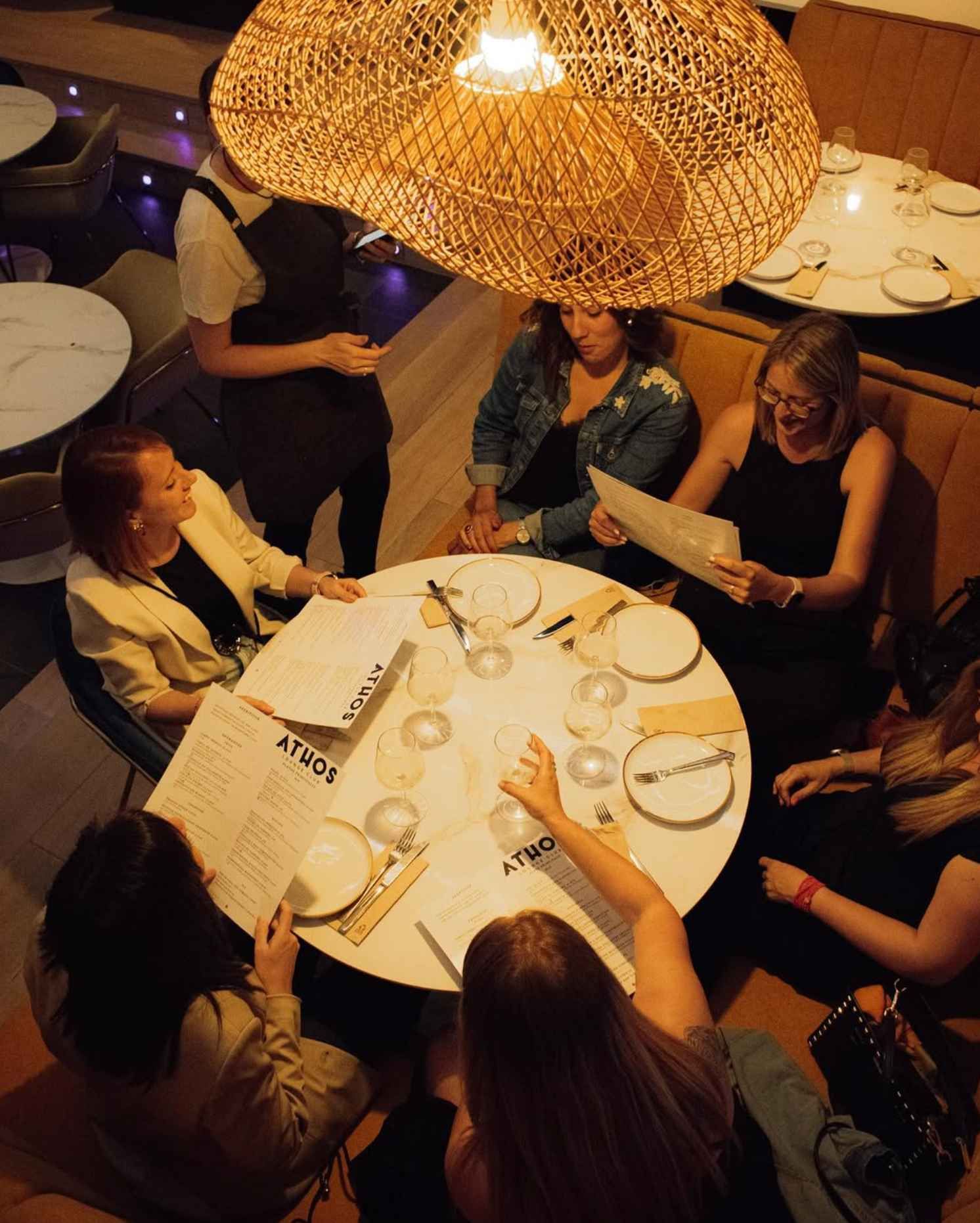 Un grupo de personas está sentado alrededor de una mesa con un menú en ella.