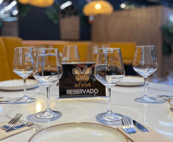 Una mesa con platos, copas de vino y un cartel que dice reservado.