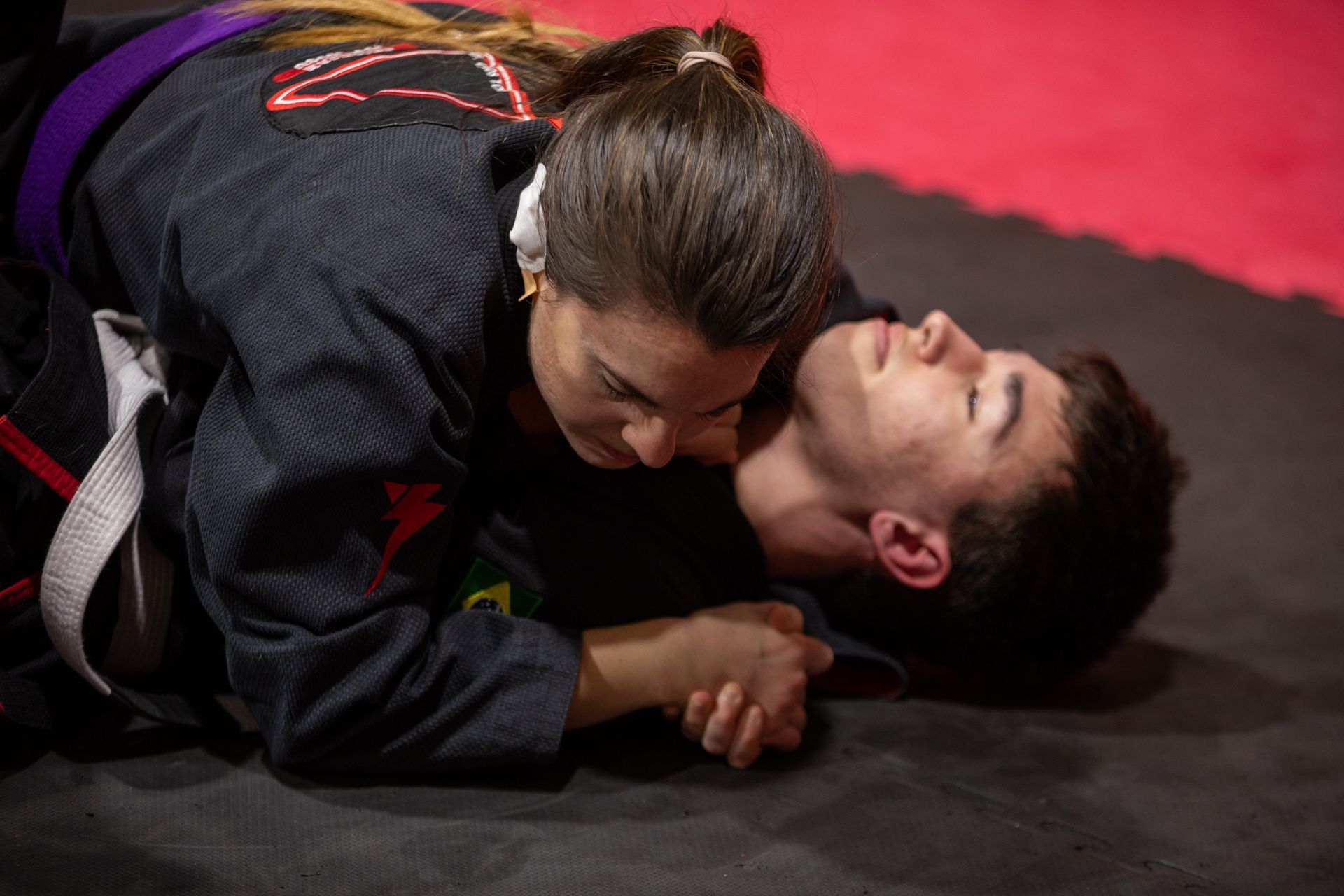 Un hombre y una mujer están luchando en una colchoneta.