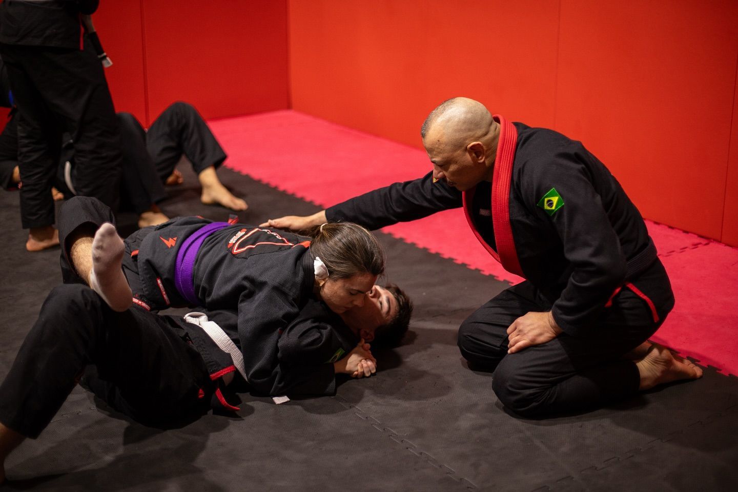 Un grupo de hombres está practicando jiu jitsu en un gimnasio.