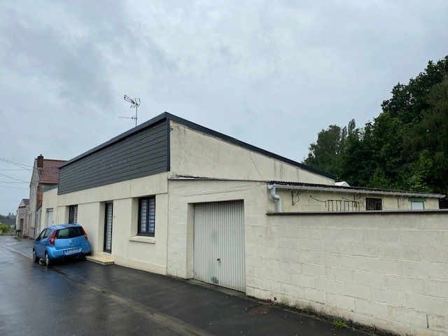 Bardage de maison beige avec voiture bleue devant