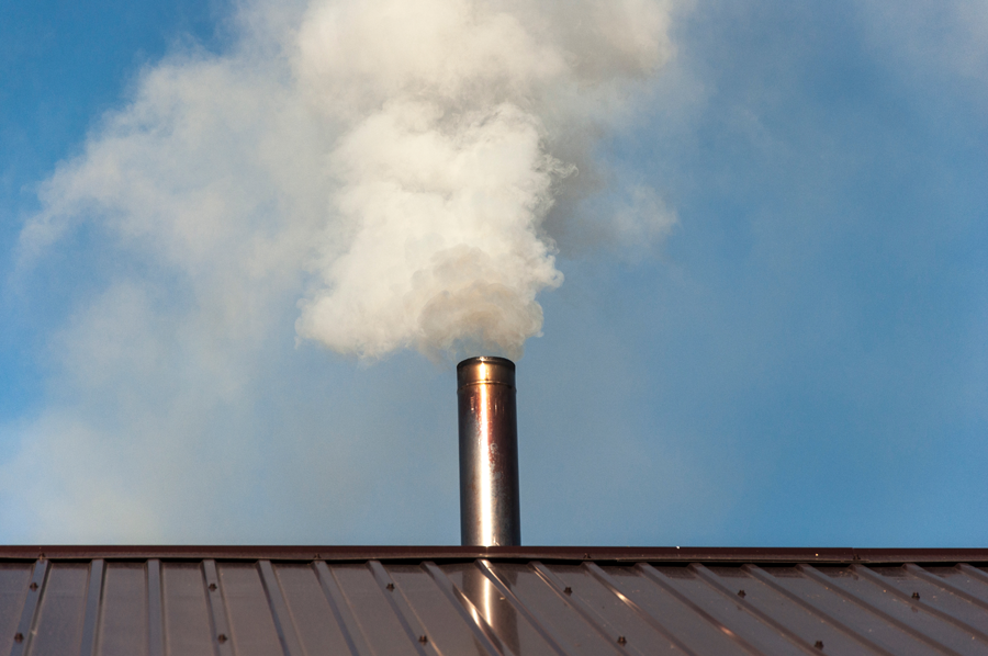 Fumée sortant d'une cheminée sur un toit