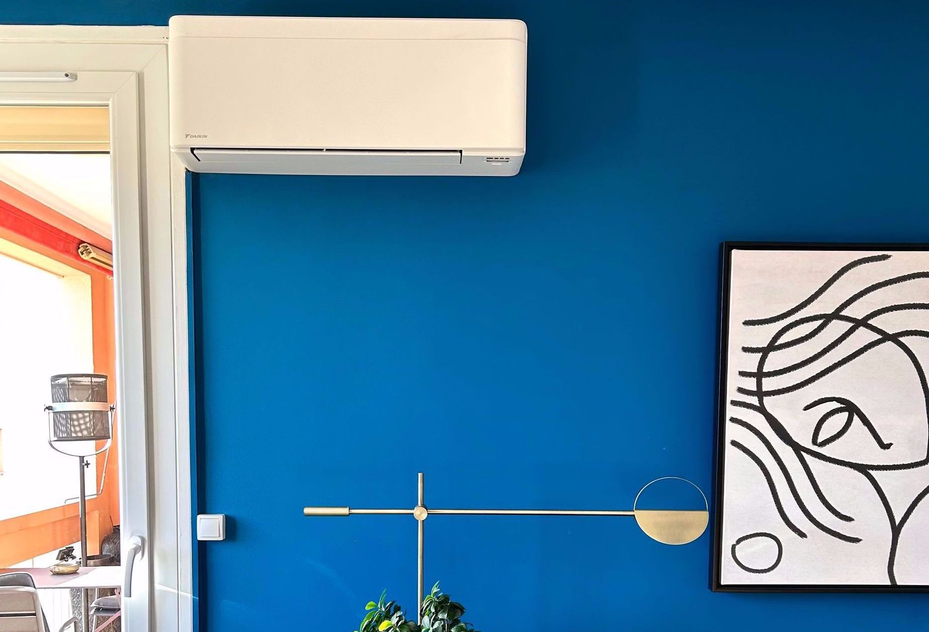 Climatiseur blanc fixé en hauteur à côté d'une porte