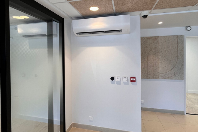 Climatiseur et homme travaillant sur un bureau vu du dessus
