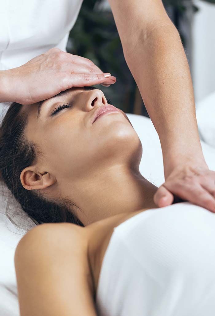 Una mujer está recibiendo un masaje de cabeza en un spa.