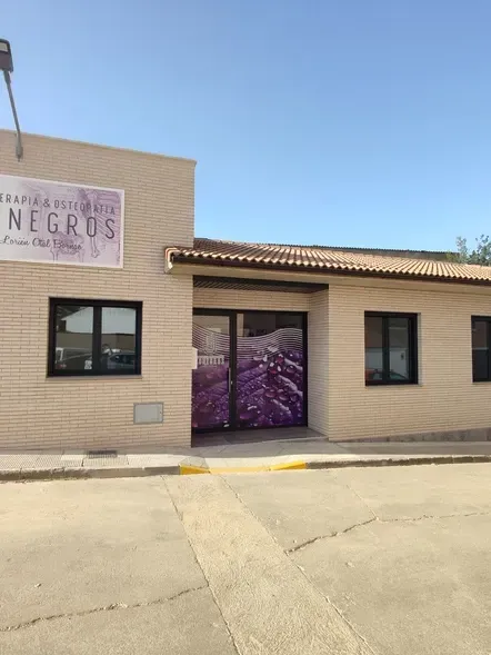 Sede empresa con una puerta tres ventanas, techo y fachada de color beige.