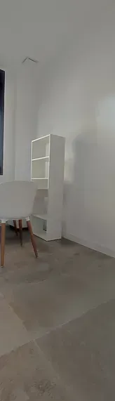 Una imagen borrosa de una sala de estar con una mesa y estantes.