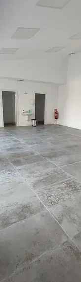 Una gran habitación vacía con suelo de baldosas y paredes blancas.