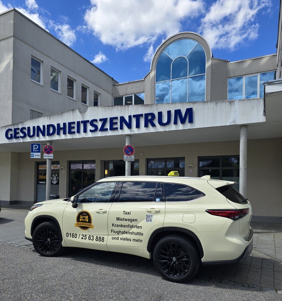 Ein gelbes Taxi parkte vor einem Gebäude mit der Aufschrift „GESUNDHEITSZENTRUM“. Sonniger Tag.