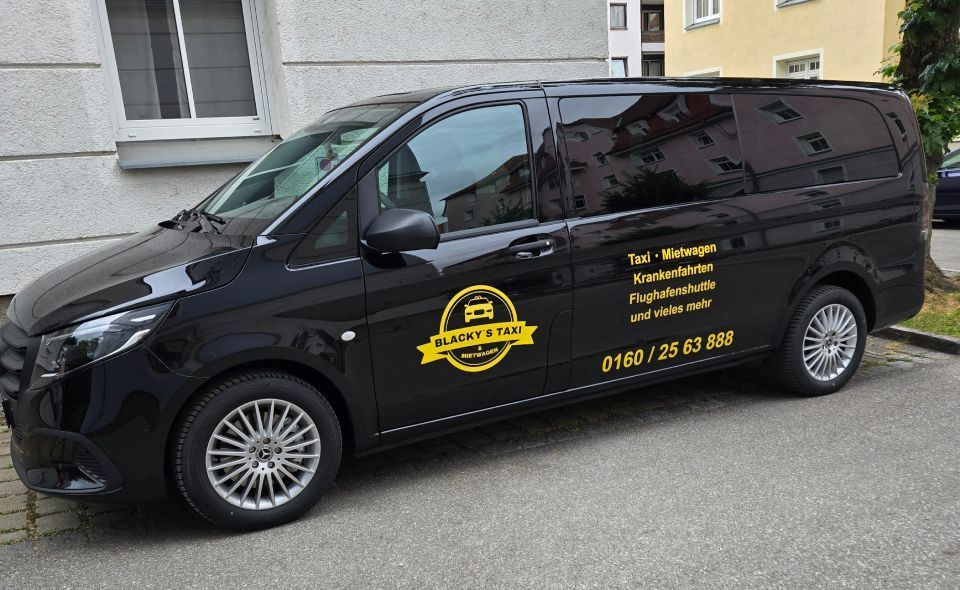 Schwarzer Lieferwagen mit gelb-schwarzem Logo und Kontaktinformationen parkt auf einer Straße.