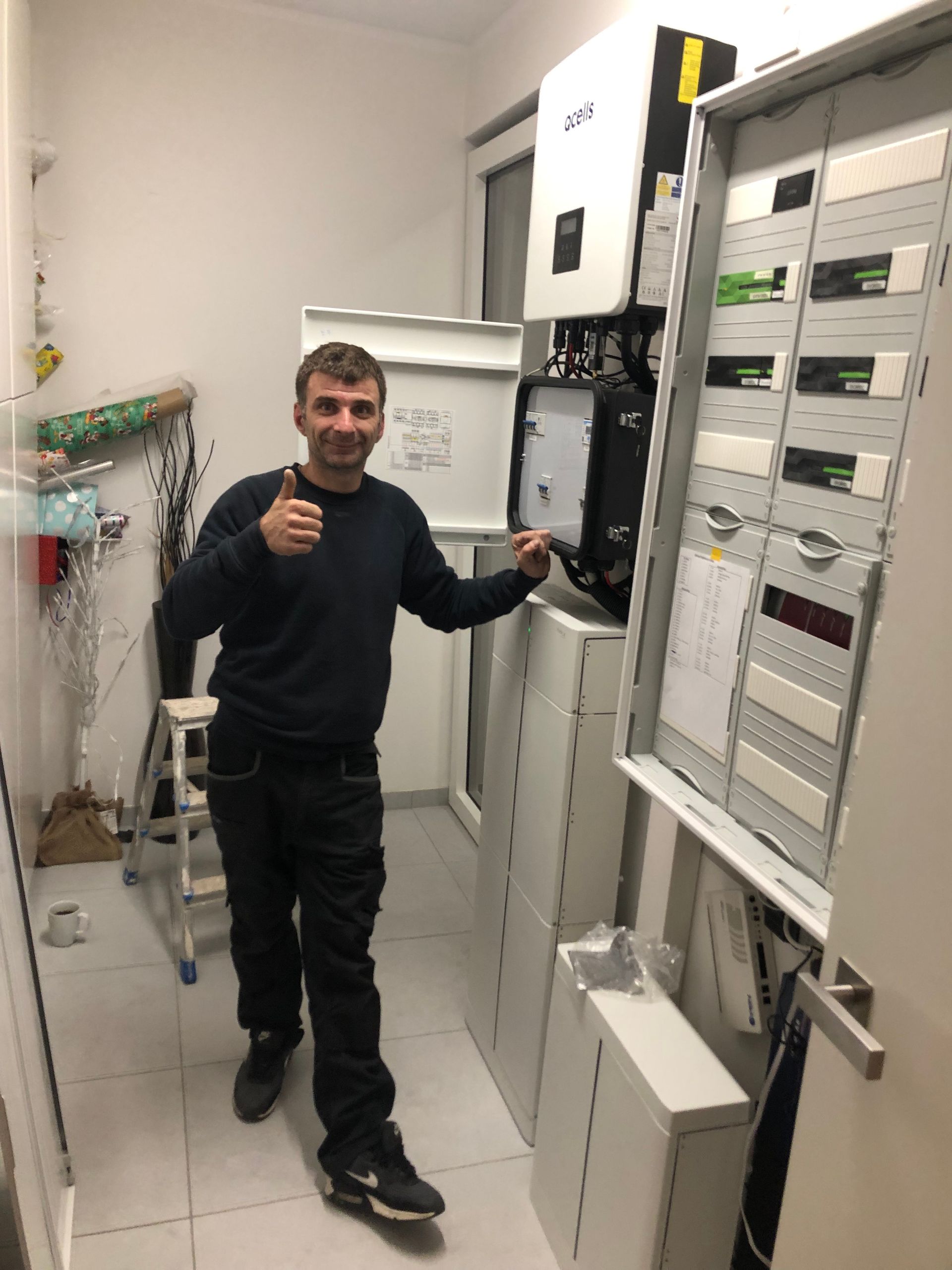 Zwei Arbeiter installieren Solarmodule auf einem Dach mit Bergblick.