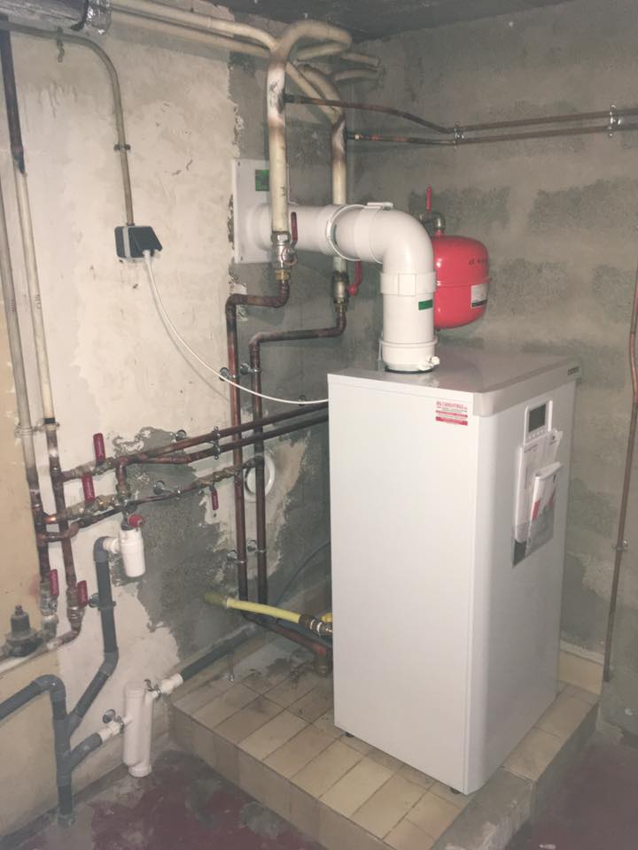 Photo d'une réparation de chaudière dans une cave de maison