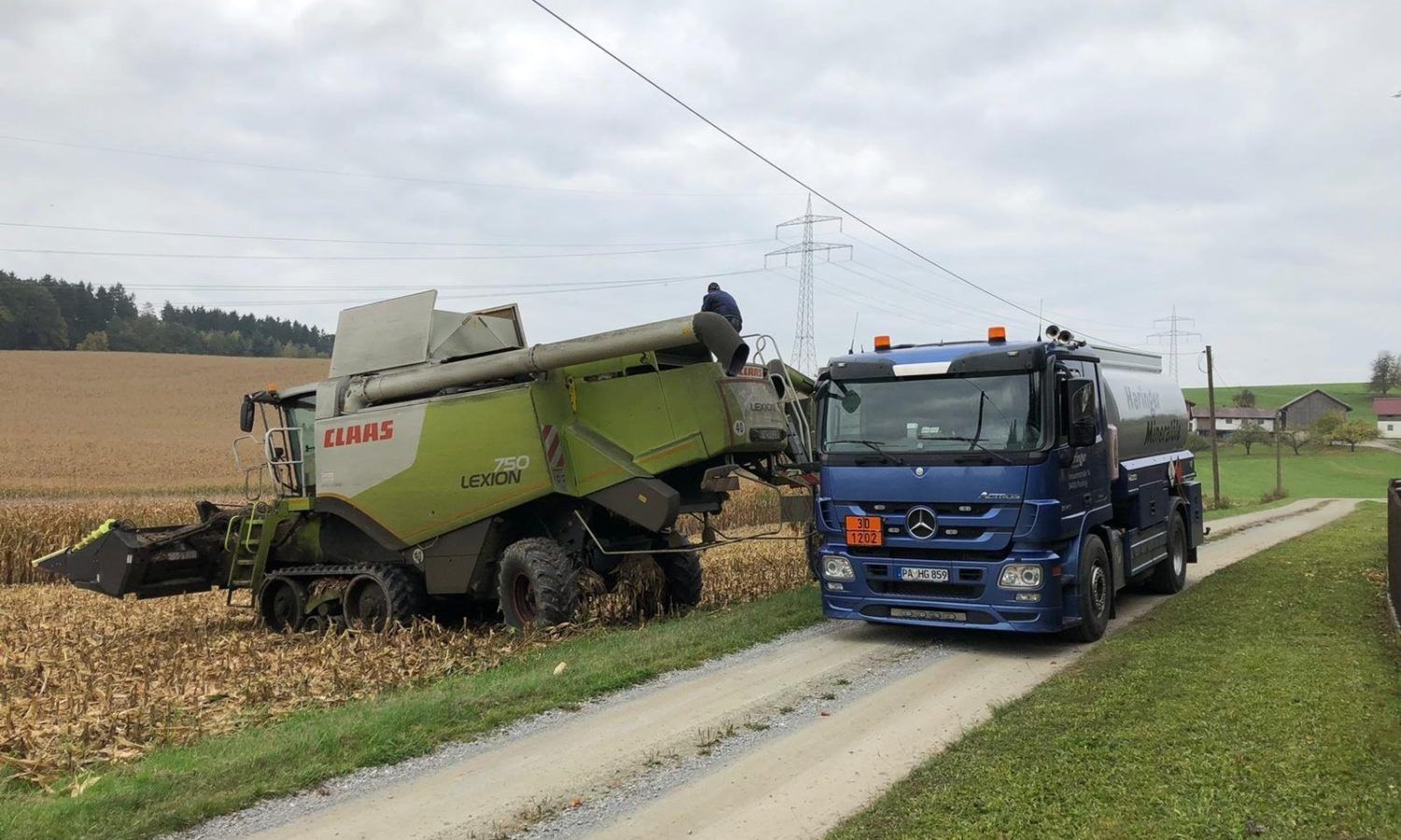 LKW und landwirtschaftliches Fahrzeug von Haringer Mineralöle und Transporte GmbH im Feld