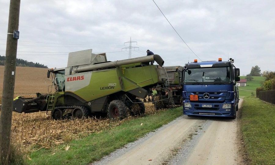 LKW und landwirtschaftliches Fahrzeug von Haringer Mineralöle und Transporte GmbH im Feld