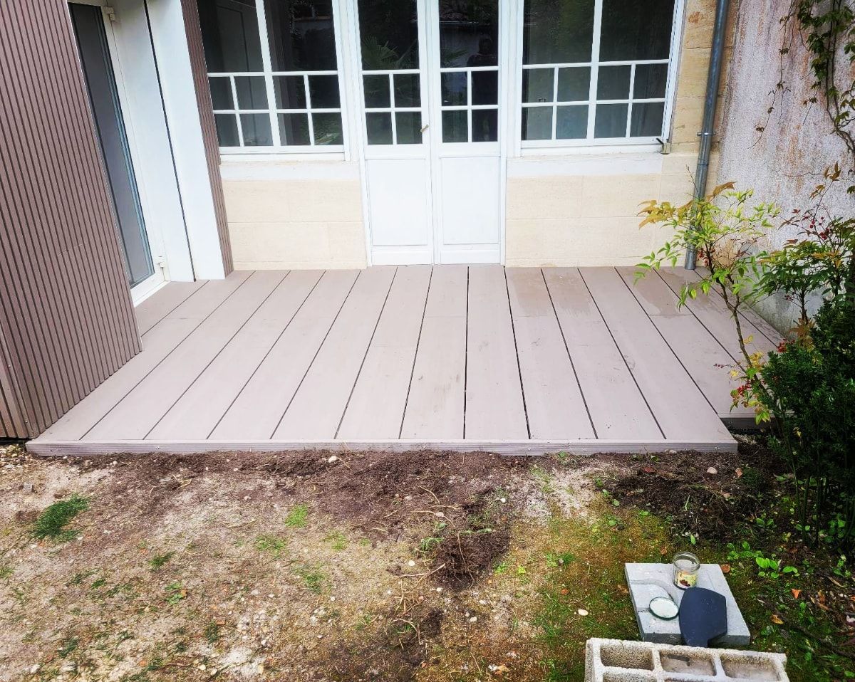 Terrasse en bois installée devant une porte d'entrée
