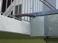 Eine Person mit Handschuhen arbeitet draußen auf einem Dach an einem Kabel.
