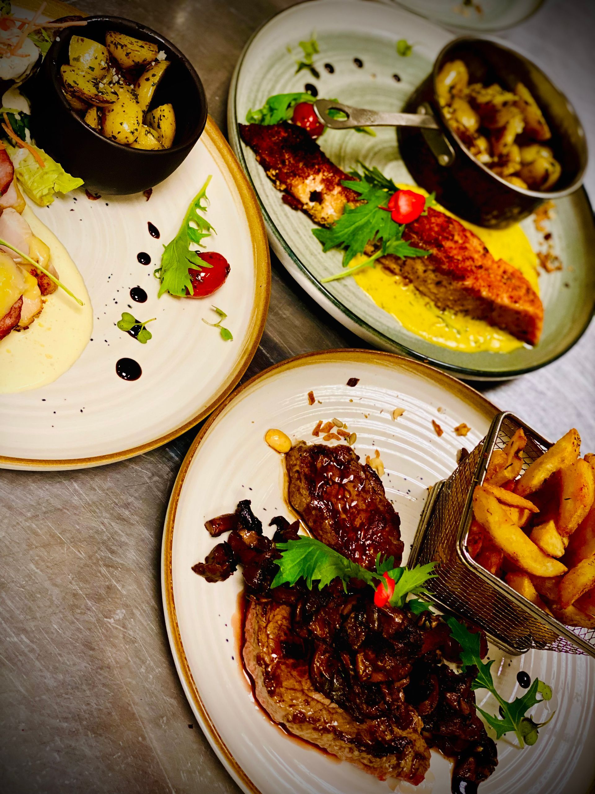 Trois assiettes avec de la viande et des frites