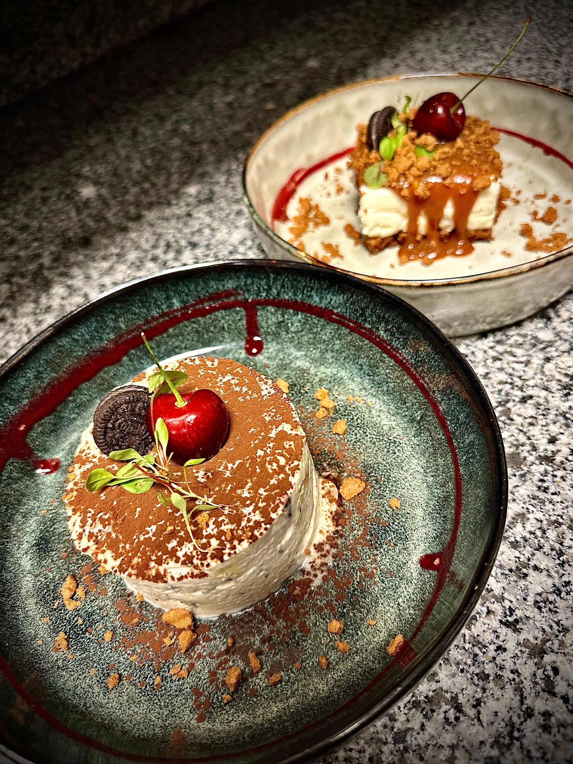 Deux assiettes cruses avec des desserts à la cerise