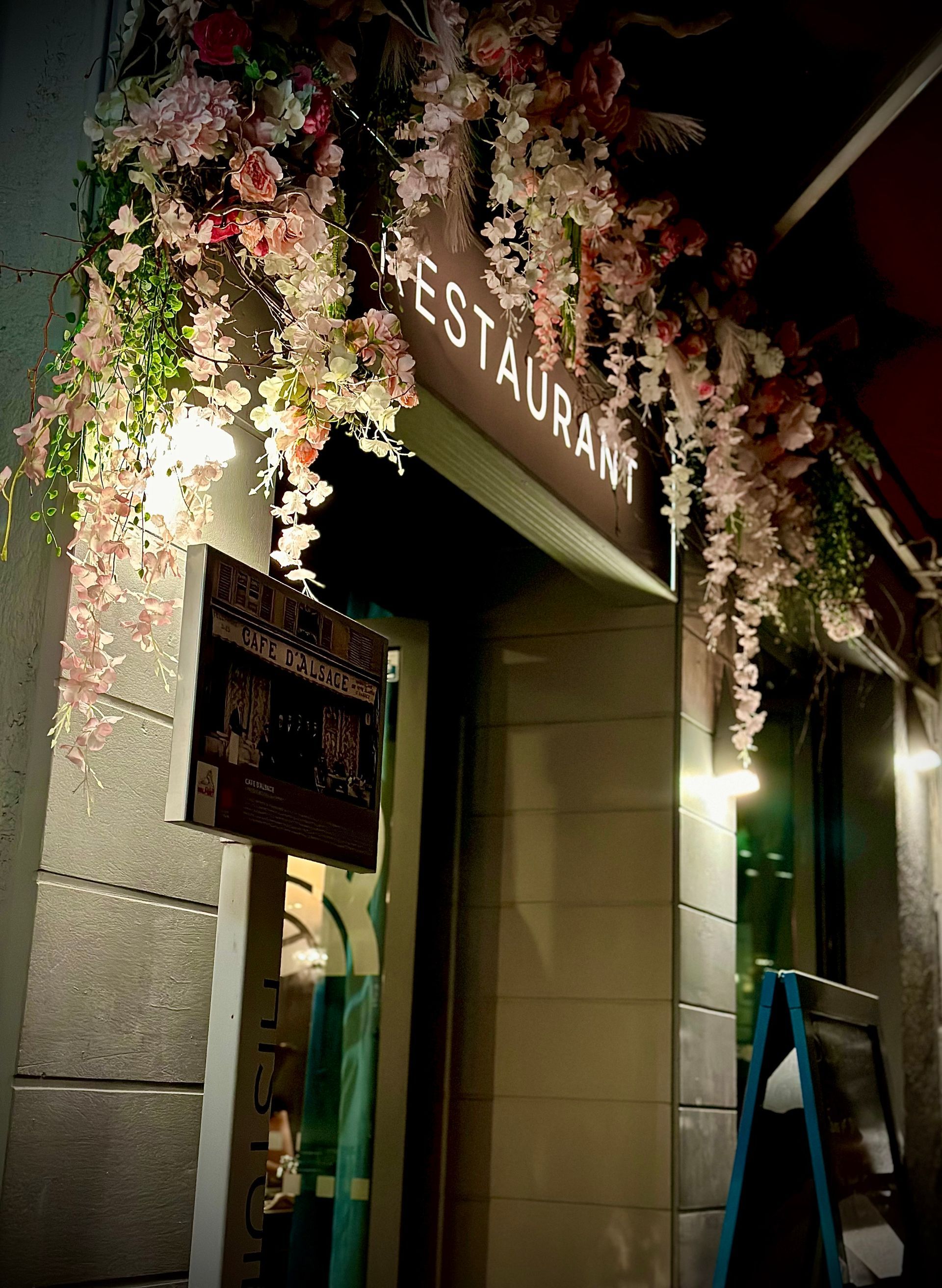 Faux rosier accroché à la devanture d'un restaurant de nuit