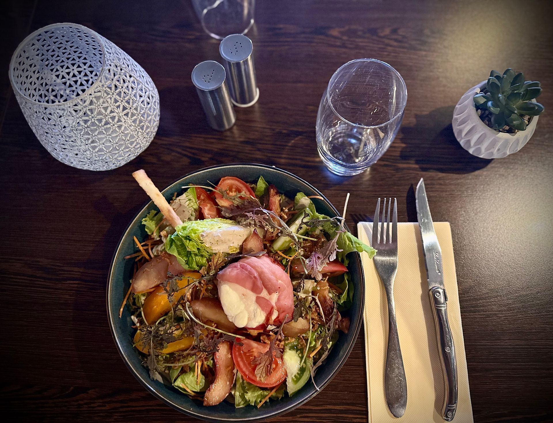 Table avec une assiette remplie, des couverts et un verre