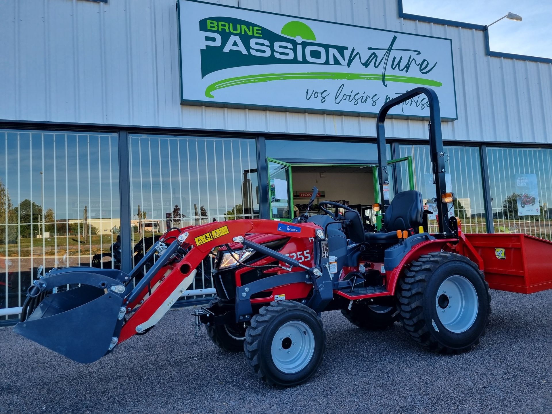 Engin agricole rouge devant la boutique