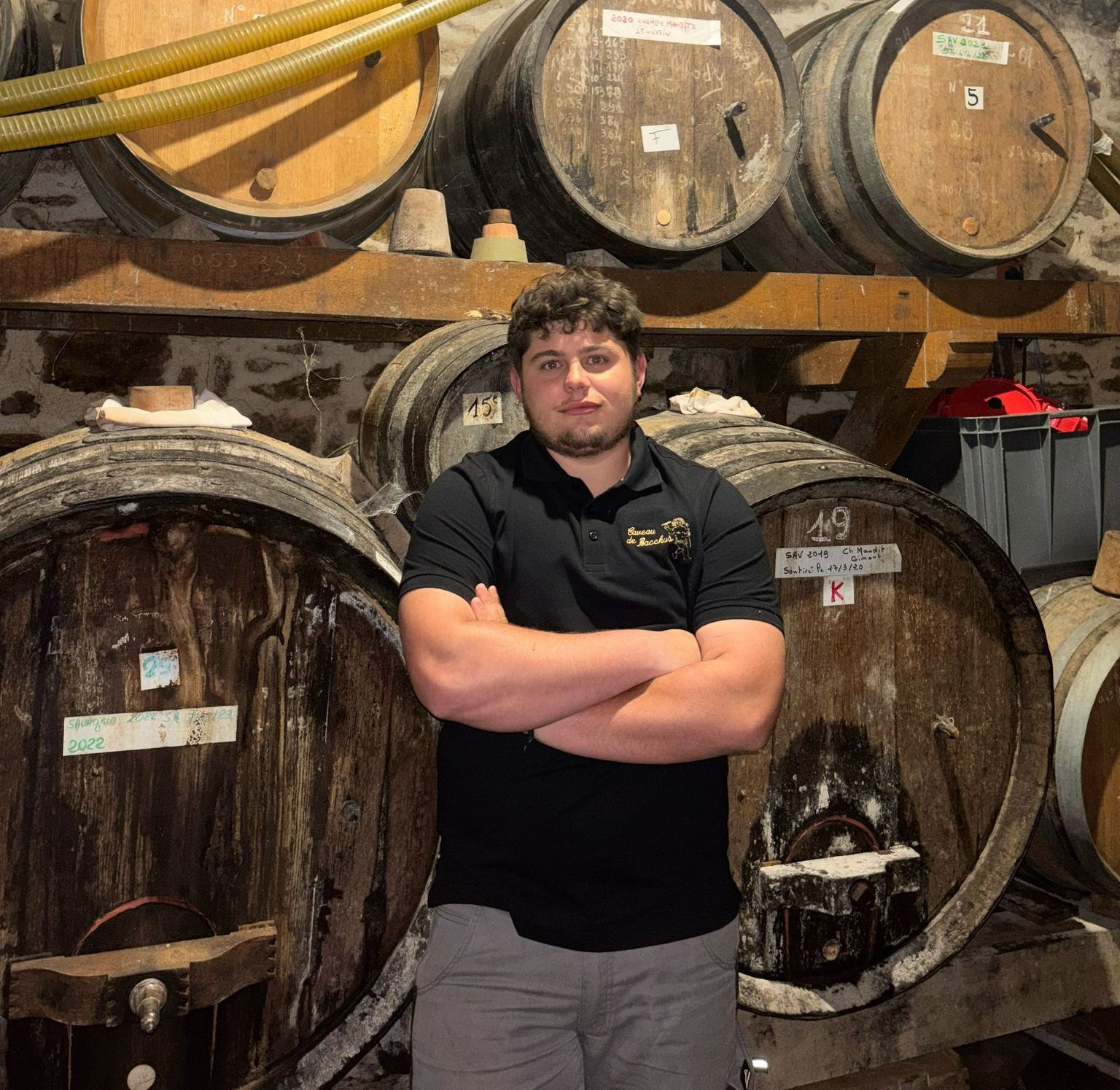 Un jeune homme devant des tonneaux