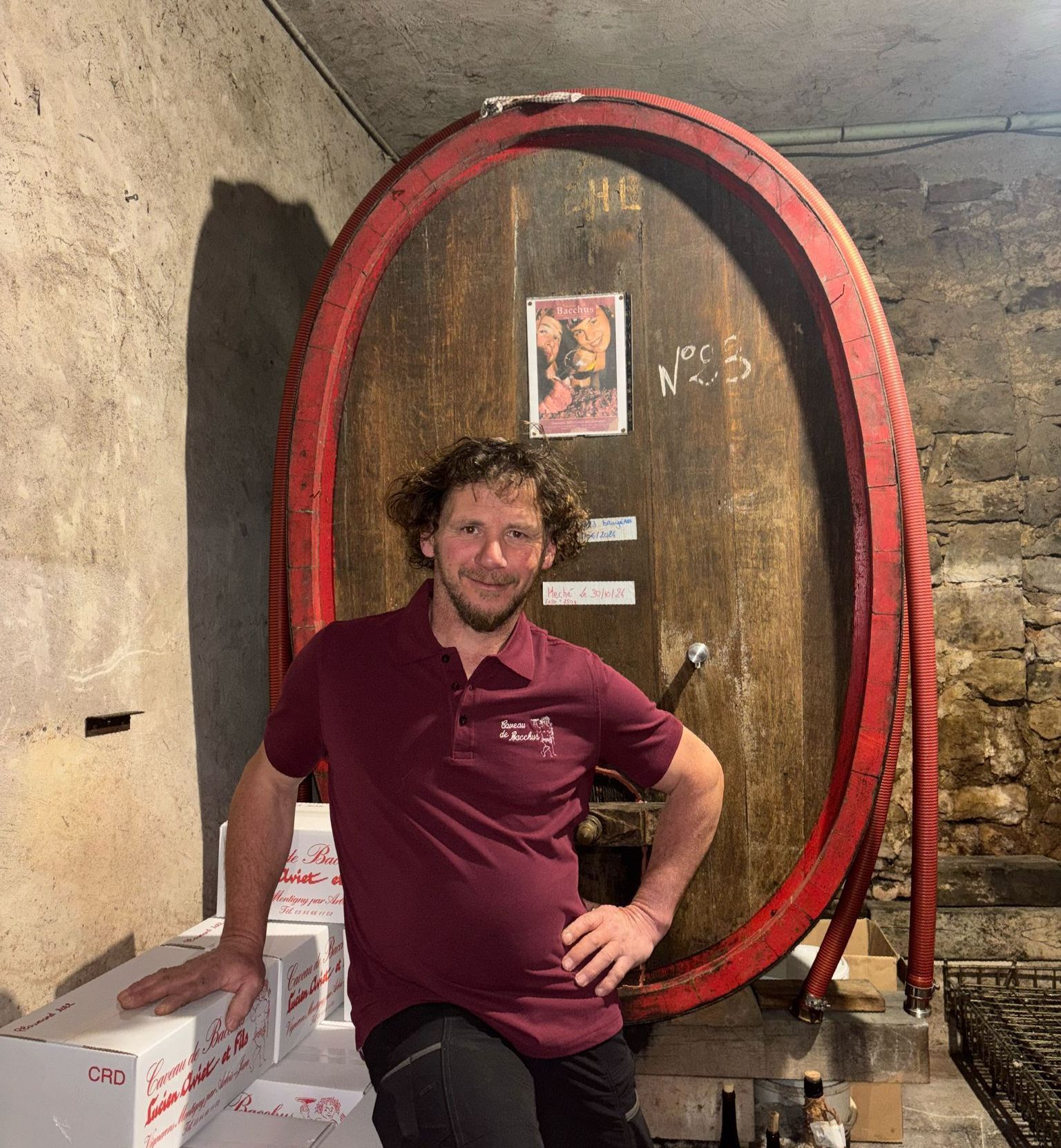Un homme devant des tonneaux de vin