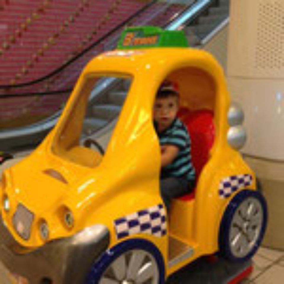 Kind in einem Taxispielmaschine