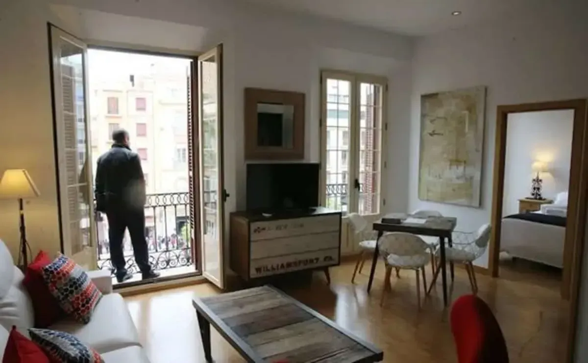 Un hombre está parado en un balcón en una sala de estar.