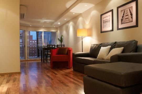 Una sala de estar con un sillón y una otomana.