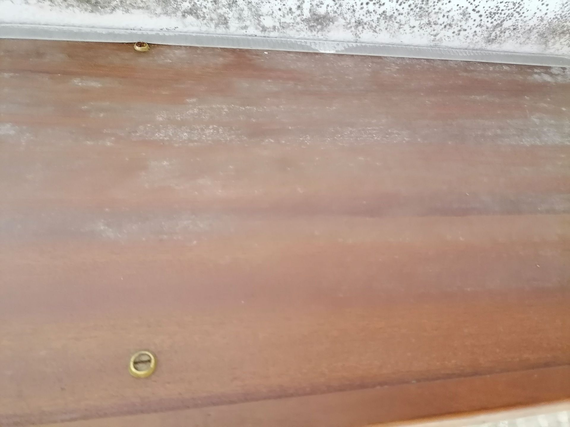 Un primer plano de una puerta de madera con un tornillo.