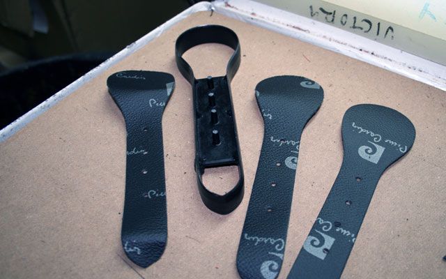 Tres piezas de cuero negro con la letra p en ellas
