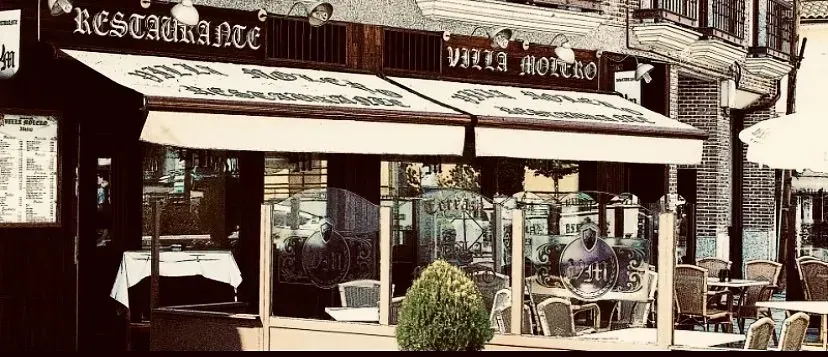 Un restaurante con mesas y sillas delante.