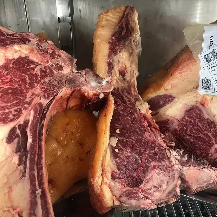 Un gran trozo de carne se encuentra en un refrigerador.