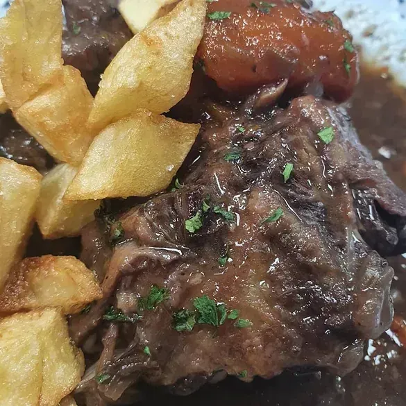 Un primer plano de un plato de comida con papas fritas y salsa.