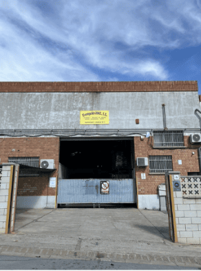 Una camioneta blanca está estacionada frente a un edificio de ladrillos.