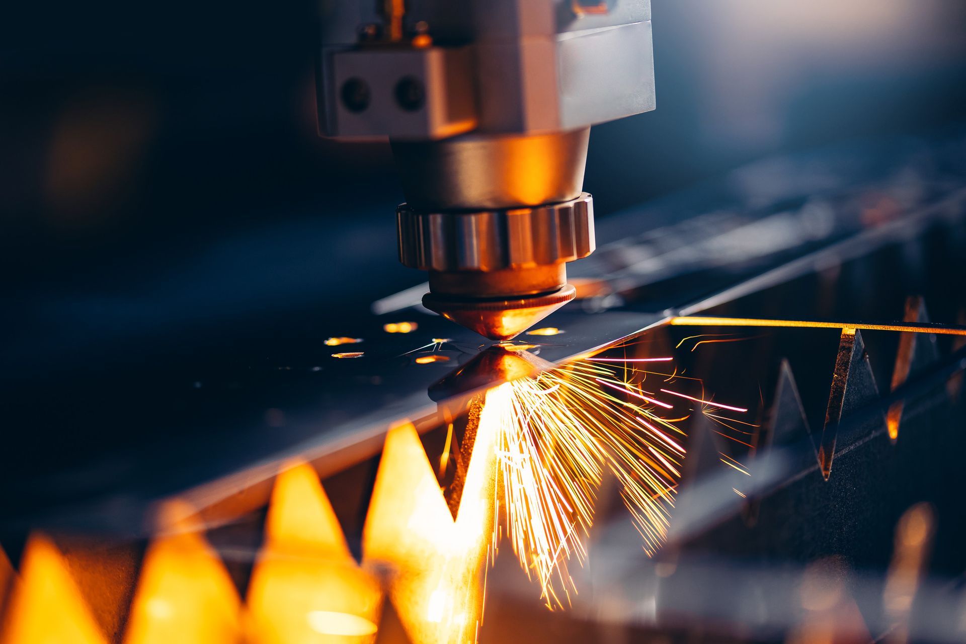 Cortadora láser que corta metal con precisión y crea chispas en un taller.