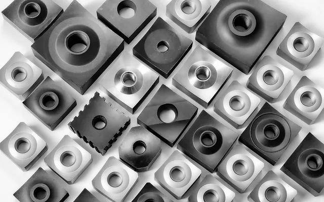 Maquinas industriales amarillas en una fábrica, enfocadas en la más cercana con un panel de control, produciendo artículos.