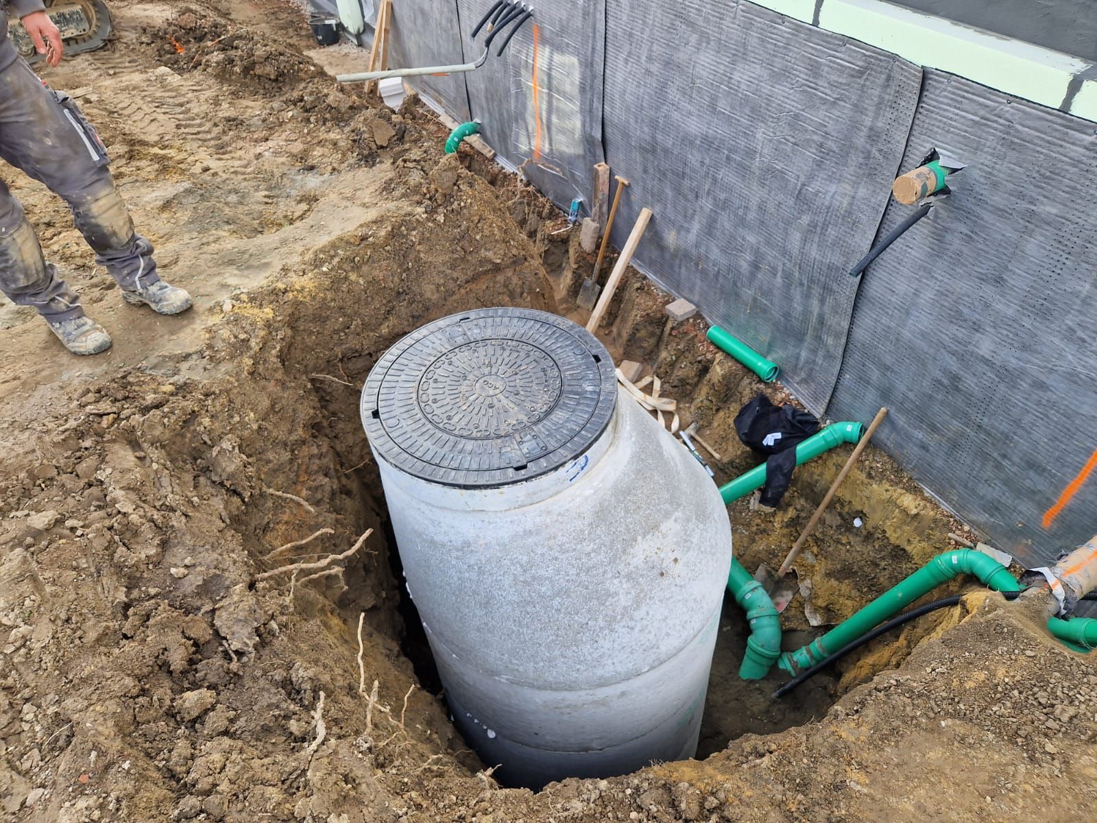 In der Mitte eines Lochs im Boden befindet sich ein Gullydeckel.