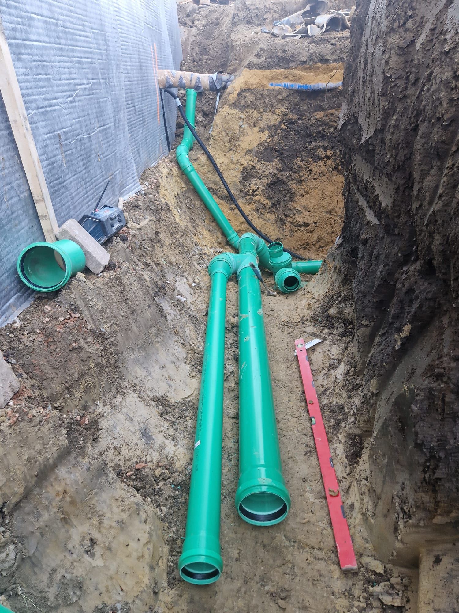 Ein Haufen grüner Rohre liegt im Dreck.