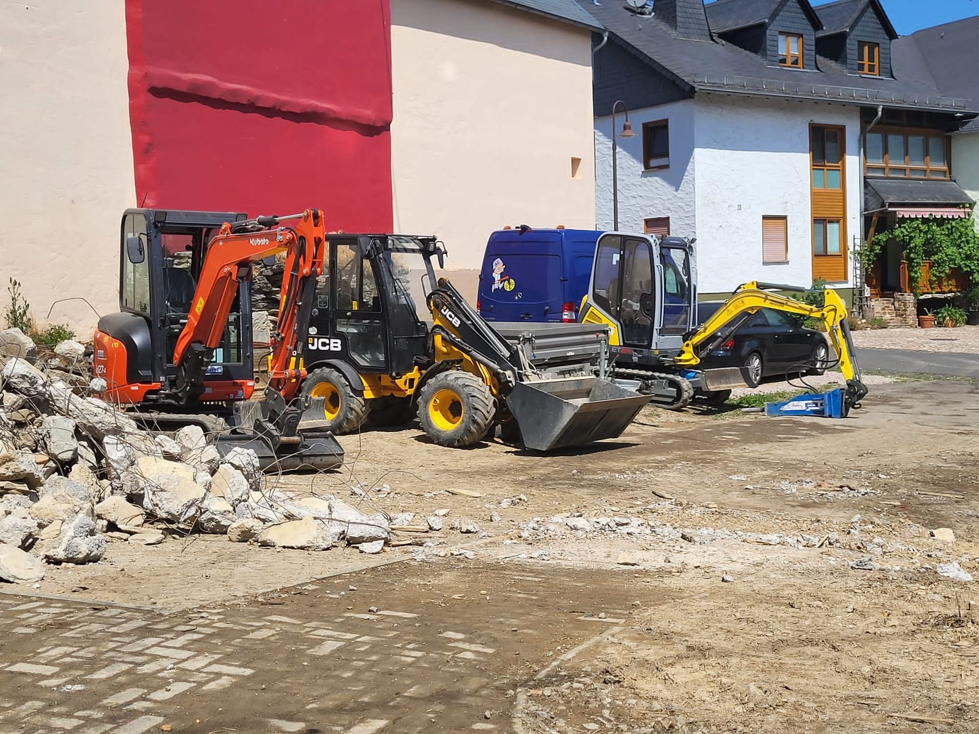 Eine Gruppe von Baufahrzeugen parkt vor einem Gebäude.
