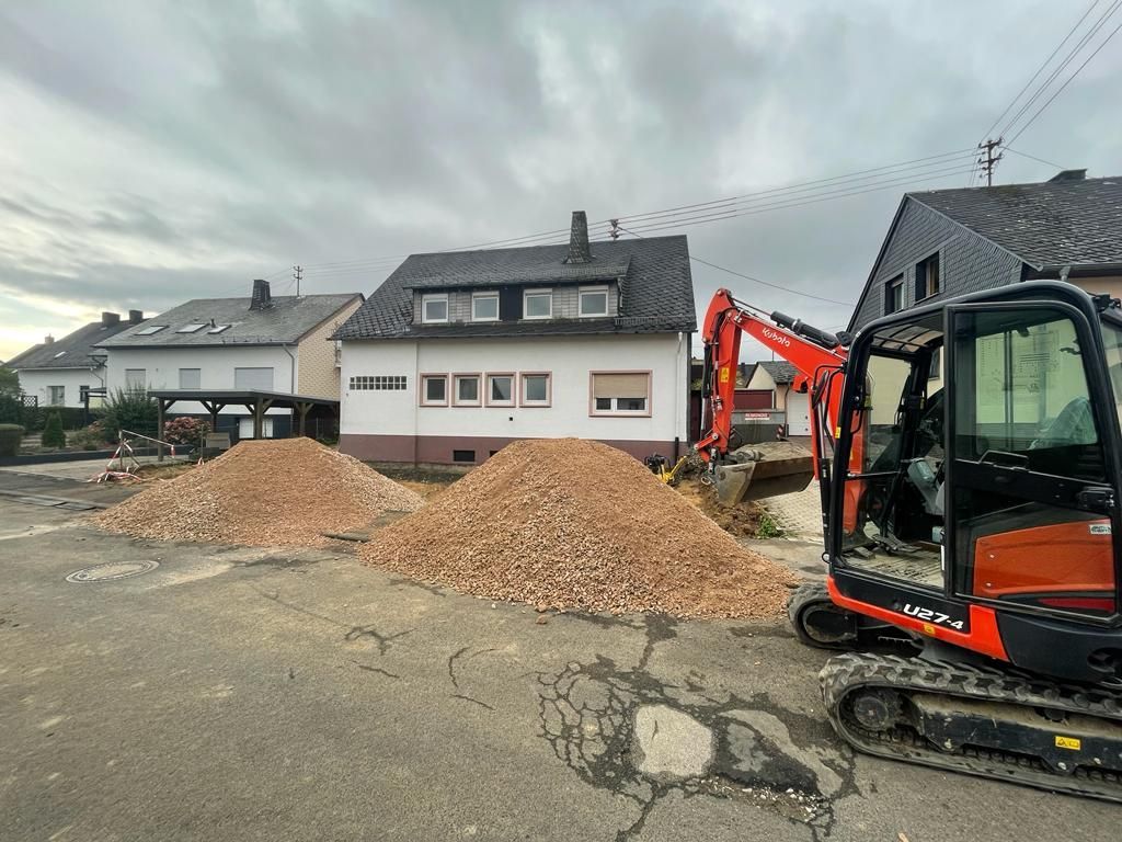 Eine Baustelle mit einem Erdhaufen vor einem Haus.
