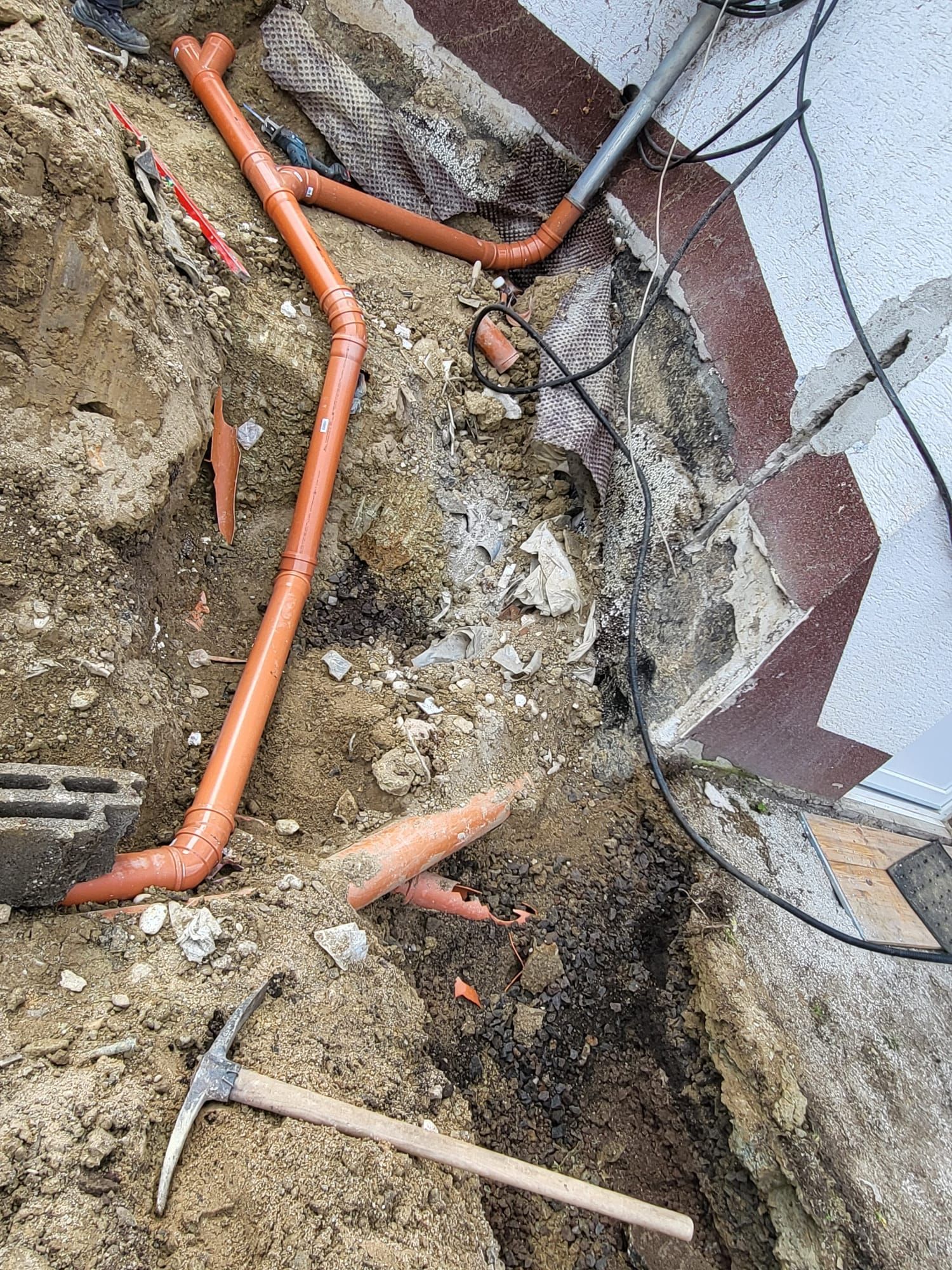 Ein Erdhaufen mit einer Schaufel und einer Spitzhacke darin.